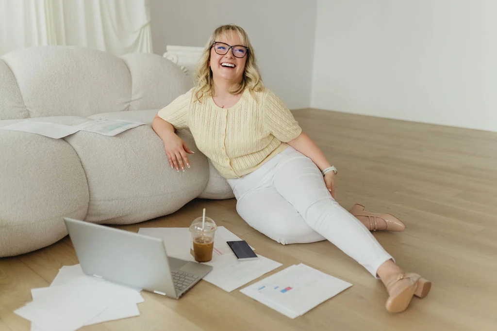Stephanie, Founder and Growth Strategist, is sitting on the floor smiling and is a Google Ads Specialist Edmonton.