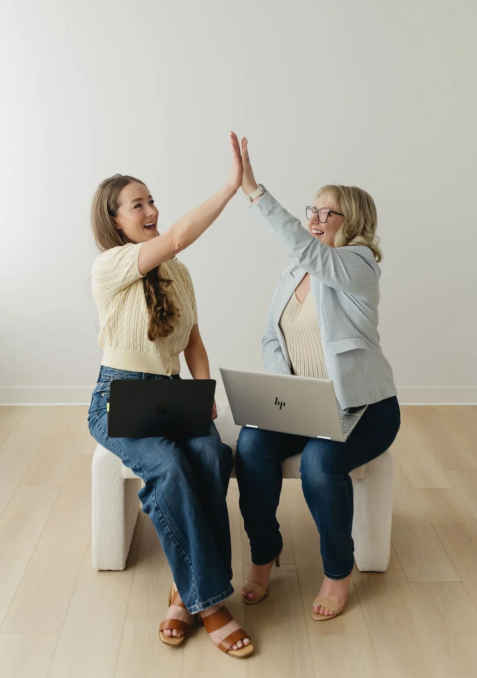 Stephanie and Melody high-fiving after completing another great marketing campaign after following their solid Paid Advertising Process Edmonton.